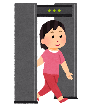 空港の金属探知機を通る女性